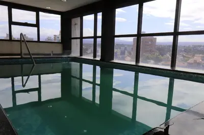 a swimming pool in a building with windows at Hotel Ananque in Villa Carlos Paz