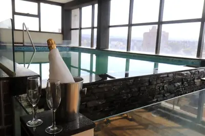 a swimming pool with two wine glasses and a banana at Hotel Ananque in Villa Carlos Paz