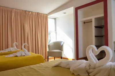 two swans towels on two beds in a room at Hotel Ananque in Villa Carlos Paz