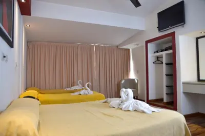 two beds in a room with towels on them at Hotel Ananque in Villa Carlos Paz