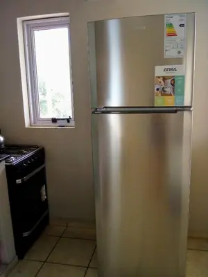 a stainless steel refrigerator in a kitchen with a window at Luminoso y bello departamento en Carlos Paz in Villa Carlos Paz