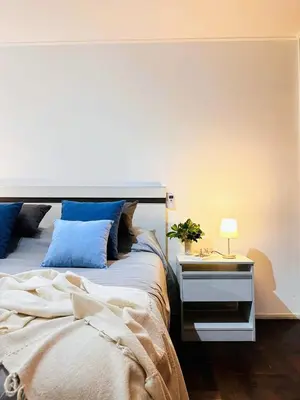 a bedroom with a bed and a table with a lamp at El mejor Dpto en Nva Cordoba al alcance de todo!frente Sanatorio Allende in Cordoba