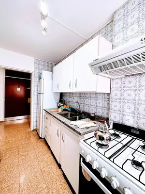 a kitchen with white cabinets and a stove top oven at El mejor Dpto en Nva Cordoba al alcance de todo!frente Sanatorio Allende in Cordoba