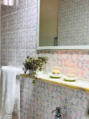 a bathroom with pink tiled walls and a sink with candles at El mejor Dpto en Nva Cordoba al alcance de todo!frente Sanatorio Allende in Cordoba