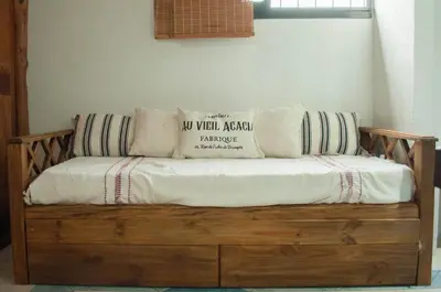 a wooden couch with pillows on top of it at Casa Villa in Cordoba