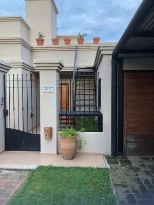 a white house with a black gate and a door at Casa Villa in Cordoba