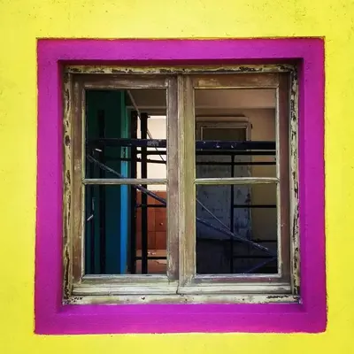a window in a yellow and pink wall at apartamento VINTAGE IVA in Merlo