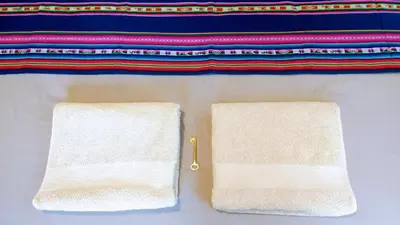 two white towels sitting next to a pair of scissors at apartamento VINTAGE IVA in Merlo