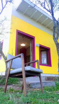 a bench in front of a yellow building at apartamento VINTAGE IVA in Merlo