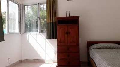 a bedroom with a bed and a dresser next to a window at Casa con pileta privada in Tanti
