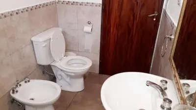 a bathroom with a toilet and a sink at Casa con pileta privada in Tanti