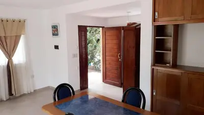 a dining room with a table and chairs and a door at Casa con pileta privada in Tanti