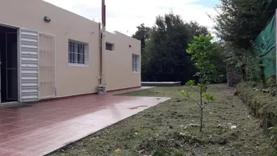 a house with a wooden deck next to a building at Casa con pileta privada in Tanti