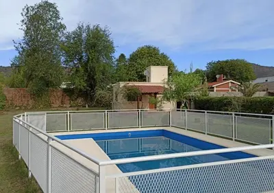 a swimming pool with a fence around it at Cabaña El Canal in Villa Carlos Paz