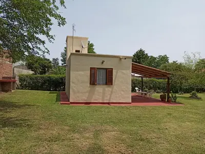 a small house in a field with a yard at Cabaña El Canal in Villa Carlos Paz
