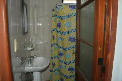 a bathroom with a sink and a shower curtain at Cabaña El Canal in Villa Carlos Paz
