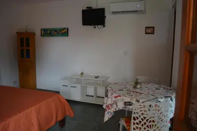 a bedroom with a table and a tv on the wall at Cabaña El Canal in Villa Carlos Paz