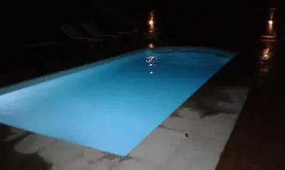 a large blue swimming pool at night at Cabañas de Montaña El Barranco in La Paz