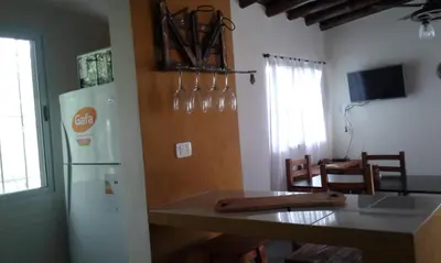 a kitchen with a refrigerator and a table with chairs at Cabañas de Montaña El Barranco in La Paz