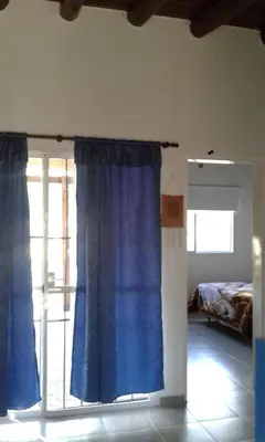 a room with a blue curtain and a bedroom at Cabañas de Montaña El Barranco in La Paz