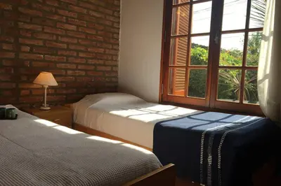 a bedroom with two beds and a window at Santa Rosa con parque y rio Ideal para familias in Santa Rosa de Calamuchita