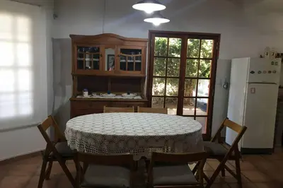 a kitchen with a table and chairs and a refrigerator at Santa Rosa con parque y rio Ideal para familias in Santa Rosa de Calamuchita