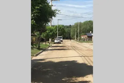 a street with a car parked on the side of the road at Santa Rosa con parque y rio Ideal para familias in Santa Rosa de Calamuchita