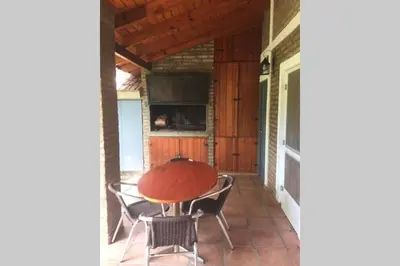 a table and chairs on the porch of a house at Santa Rosa con parque y rio Ideal para familias in Santa Rosa de Calamuchita