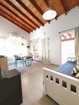 a bedroom and dining room with a bed and a table at Complejo Verde Memoria in Merlo