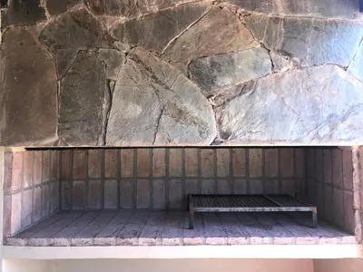 a bench sitting in front of a stone wall at Complejo Verde Memoria in Merlo