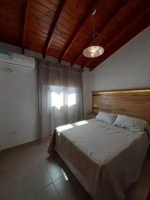a bedroom with a large bed with a wooden ceiling at Complejo Verde Memoria in Merlo