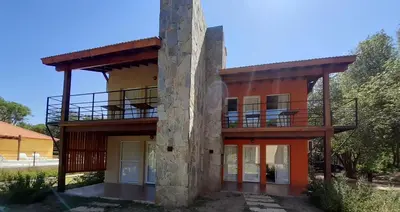a house with a balcony on the side of it at Complejo Verde Memoria in Merlo