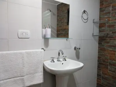 a white bathroom with a sink and a mirror at Complejo El Bosque in Villa Ciudad Parque