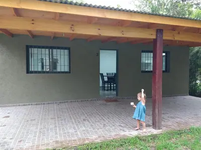 a little girl standing in front of a house at Complejo El Bosque in Villa Ciudad Parque