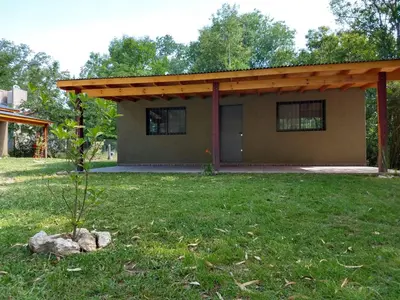 a small house with a roof in a yard at Complejo El Bosque in Villa Ciudad Parque