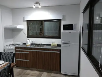 a kitchen with a white refrigerator and a sink at Complejo El Bosque in Villa Ciudad Parque