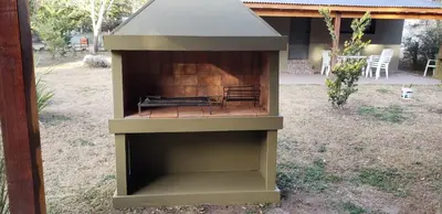 a outdoor shelter with a bench in a yard at Complejo El Bosque in Villa Ciudad Parque
