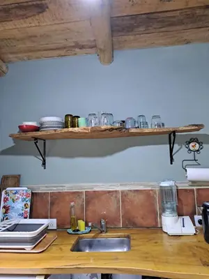 a kitchen counter with a sink and shelves on the wall at Surya- en La Casa de Nanda in San Javier