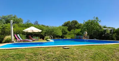 a swimming pool in a yard with an umbrella at Surya- en La Casa de Nanda in San Javier