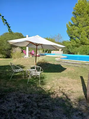 a table and chairs under an umbrella next to a pool at Surya- en La Casa de Nanda in San Javier