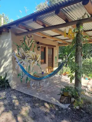 a hammock in front of a house with a painting at Surya- en La Casa de Nanda in San Javier