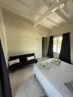 a bedroom with two beds and a couch in it at Departamentos la Piedad in Mina Clavero