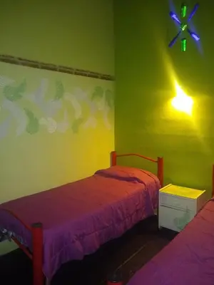 two beds in a room with green walls at La Bicicleta solar casa abierta in Villa Independencia