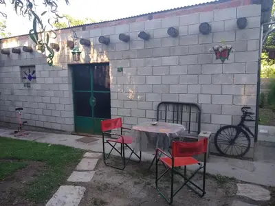 a table and chairs in front of a building at La Bicicleta solar casa abierta in Villa Independencia