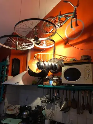 a kitchen with a bike hanging from a ceiling at La Bicicleta solar casa abierta in Villa Independencia