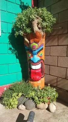 a planter with a face painted on it with plants at La Bicicleta solar casa abierta in Villa Independencia