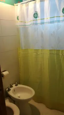 a bathroom with a sink and a toilet and a shower curtain at La Bicicleta solar casa abierta in Villa Independencia