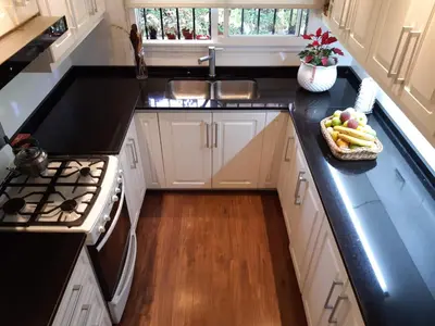 a kitchen with white cabinets and a bowl of fruit on the counter at Casa Simona Villa General Belgrano in Villa General Belgrano
