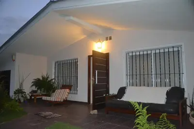 a bedroom with a bed and a chair in a room at Casa Simona Villa General Belgrano in Villa General Belgrano
