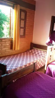 a bedroom with two beds and a window at Cabañas Alma Comechingon in Villa Cura Brochero